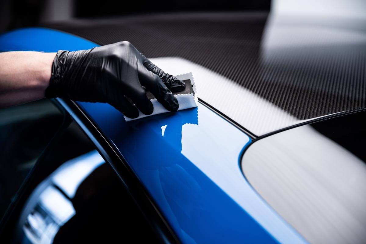 Technician applying a coat on a Porsche.